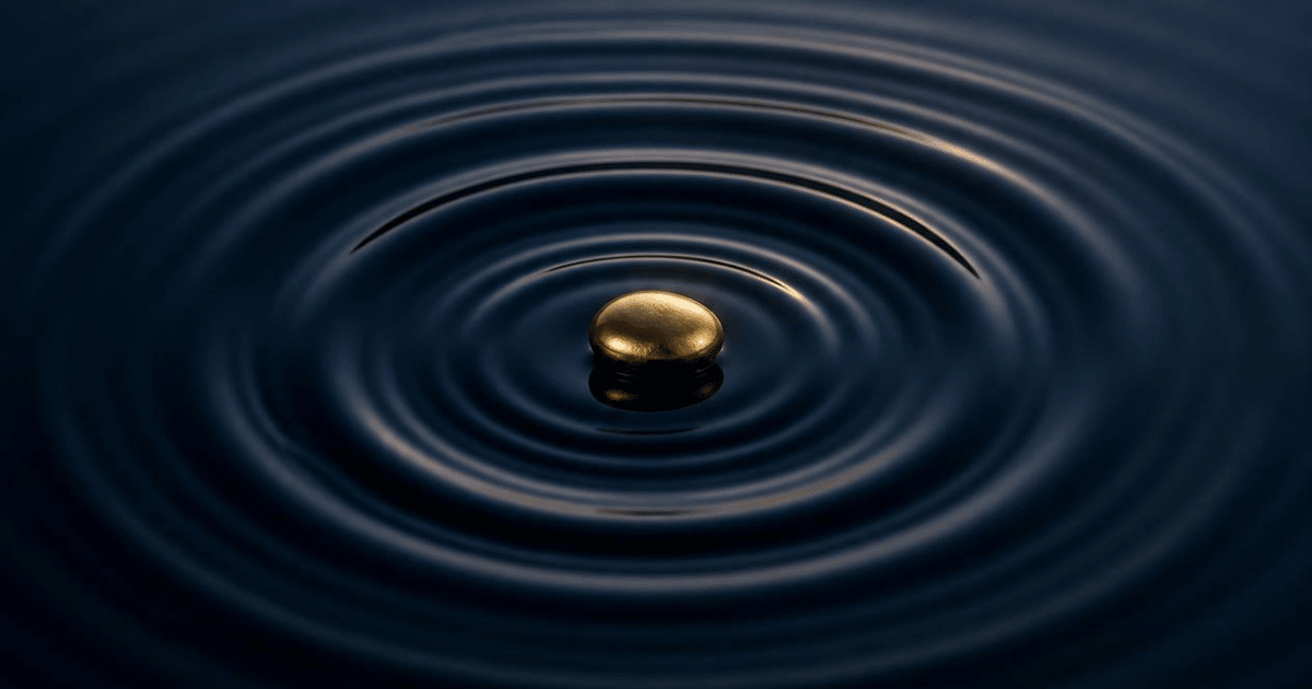 A single gold stone creates ripples across still water, symbolizing how strong leadership creates lasting impact throughout an organization.